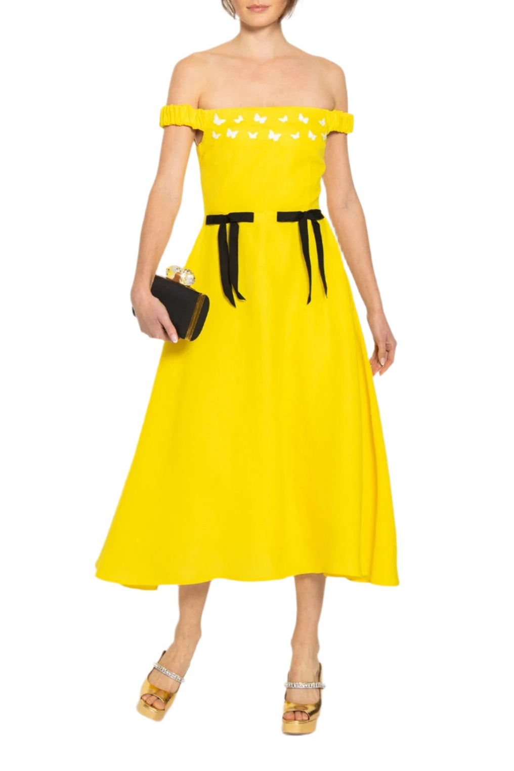 Front view of Gulderen dress in bright yellow, off-the-shoulder with white butterfly embroidery and black ribbon waist ties