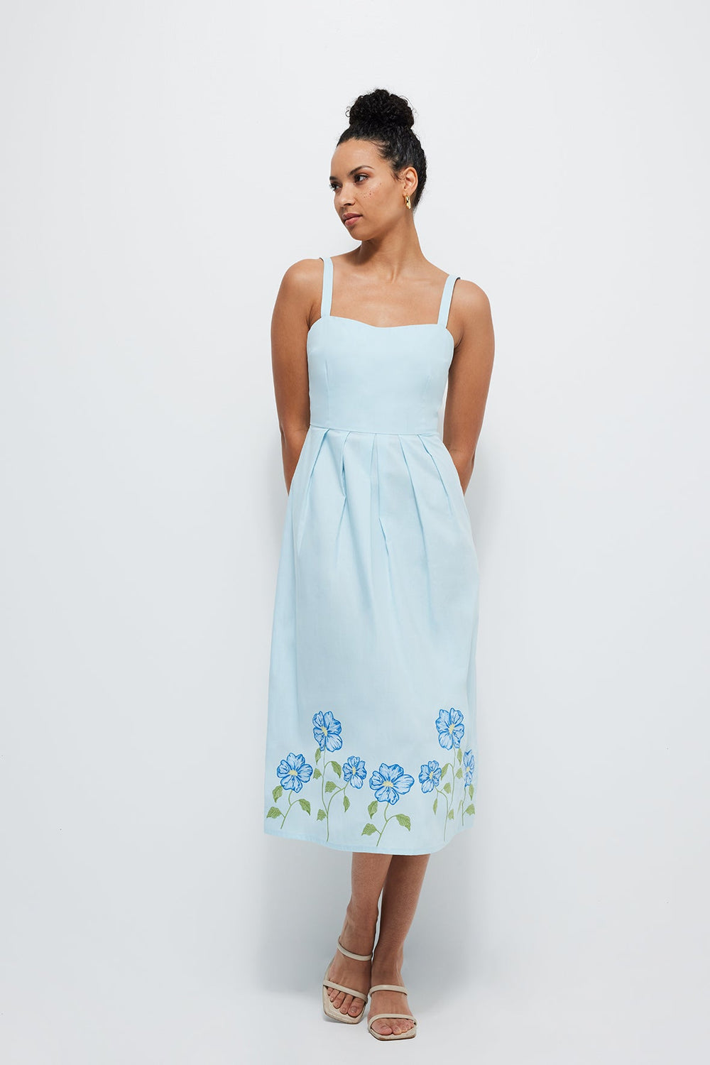 Front view of Yekdare Dress in light lagoon with square neckline, pleated midi and blue floral hem on white background