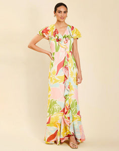 Woman wearing the Mestiza Fernanda Gown in Autumn Daydreaming print, featuring a V-neckline, cascading ruffle details, cap-style ruffle sleeves, fitted bodice, and flowing chiffon skirt.