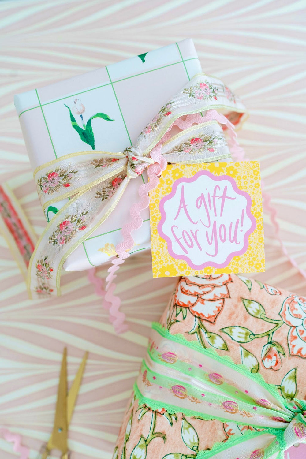 Top-down of Melon & Rose Ditsy Floral gift tag on wrapped present reading A gift for you with floral ribbon and pink ricrac