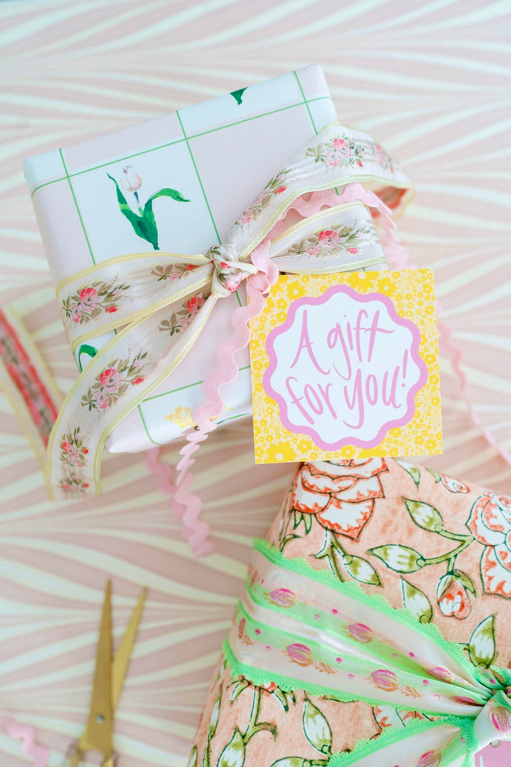 Top-down of Melon & Rose Ditsy Floral gift tag on wrapped present reading A gift for you with floral ribbon and pink ricrac