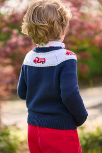 Little English traditional children's clothing. Navy crew neck sweater with red fire truck fair isle detail. Layered over white knit turtleneck with all-over fire truck print. Paired with red corduroy banded pants.  Fall outfit for toddler boys.