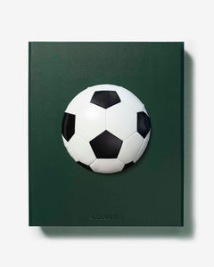 Football: The Impossible Collection by Assouline: flat front-facing view of the green leather slipcase; the dark forest green surface features a three-dimensional black-and-white soccer ball mounted at center; ASSOULINE in small embossed type at the lower center; no title text on the face; white background