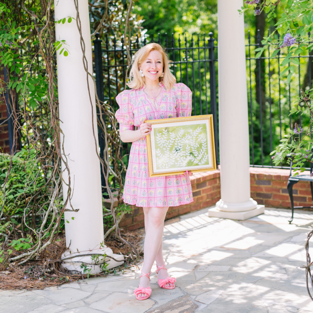Framed Chinoiserie Abstract En Vert art print with green leaf pattern held by model in pink dress outdoors