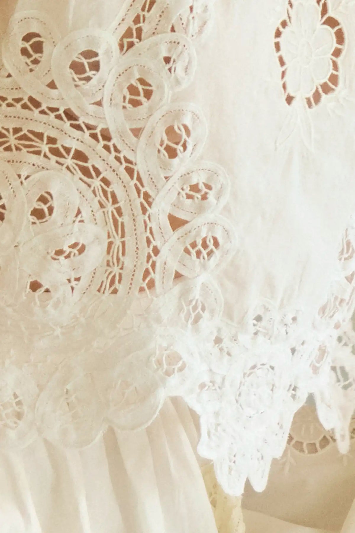 The Francesca Top in white lace has a cropped profile and sleeveless.