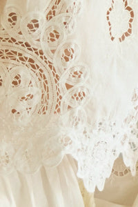 The Francesca Top in white lace has a cropped profile and sleeveless.