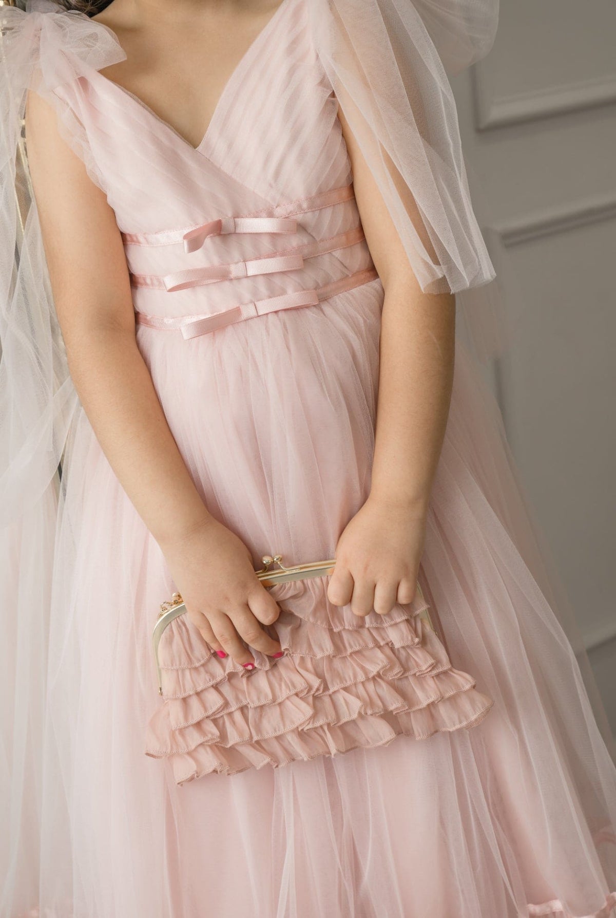 Close-up of Camila Light Pink Tulle Gown highlighting satin ribbon waist accents and soft layered tulle fabric.