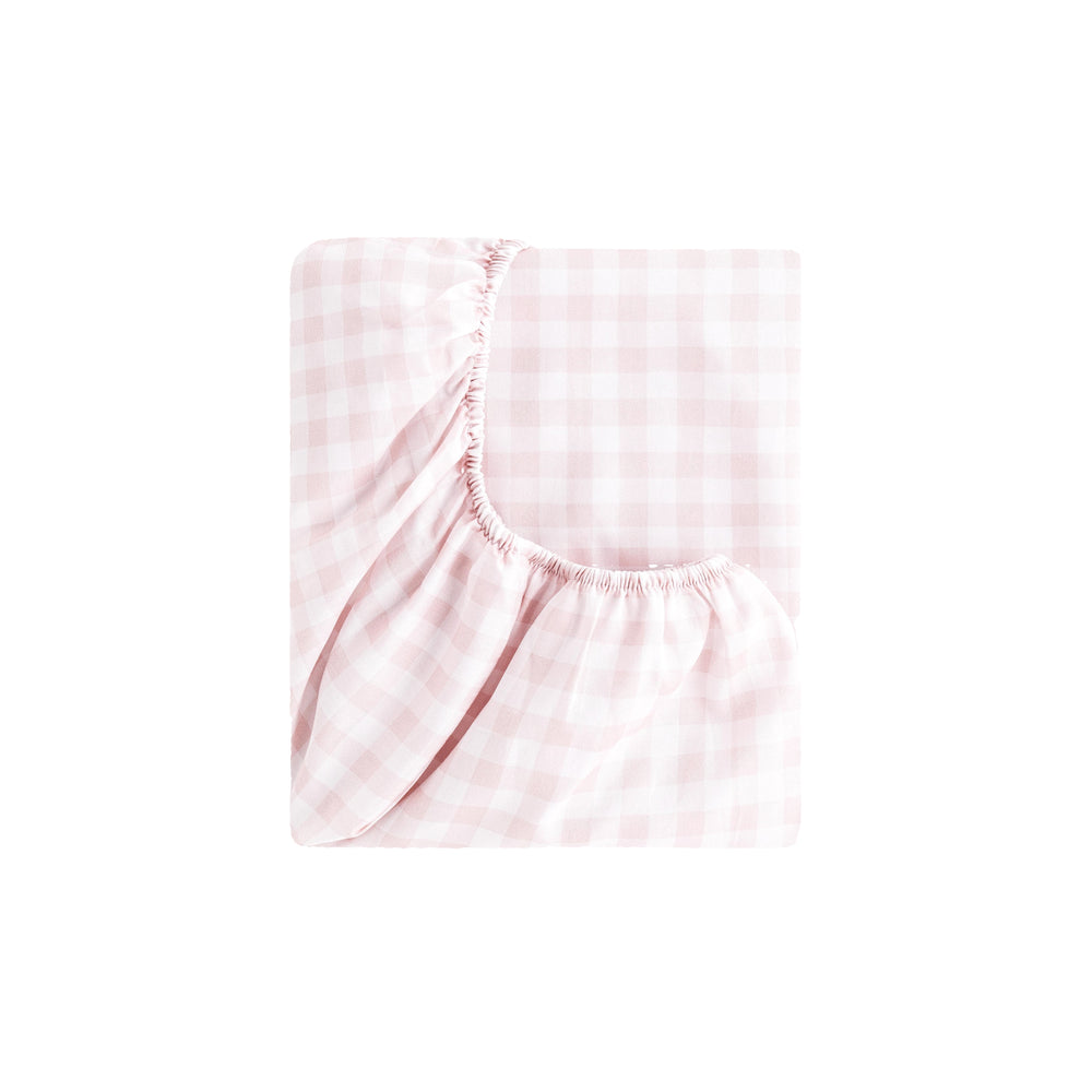 Top-down view of Picnic Gingham fitted crib sheet in pink showcasing elasticized corner and gingham pattern on white background