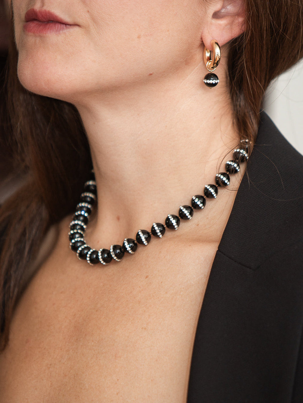 Close-up of Gisele Necklace on model showcasing faceted black onyx beads with silver spacer accents at the collar