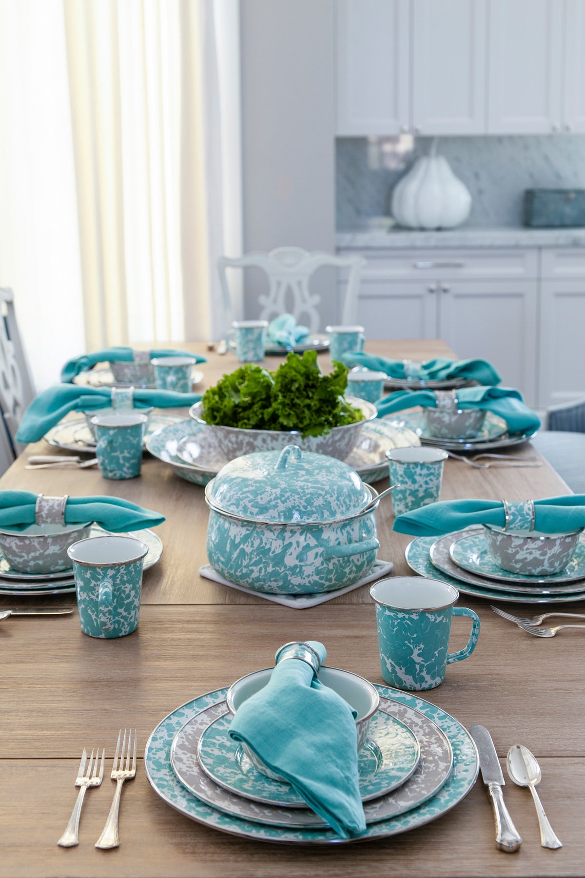 Sea Glass mugs arranged on a dining table with coordinated enamelware and turquoise napkins in a bright kitchen