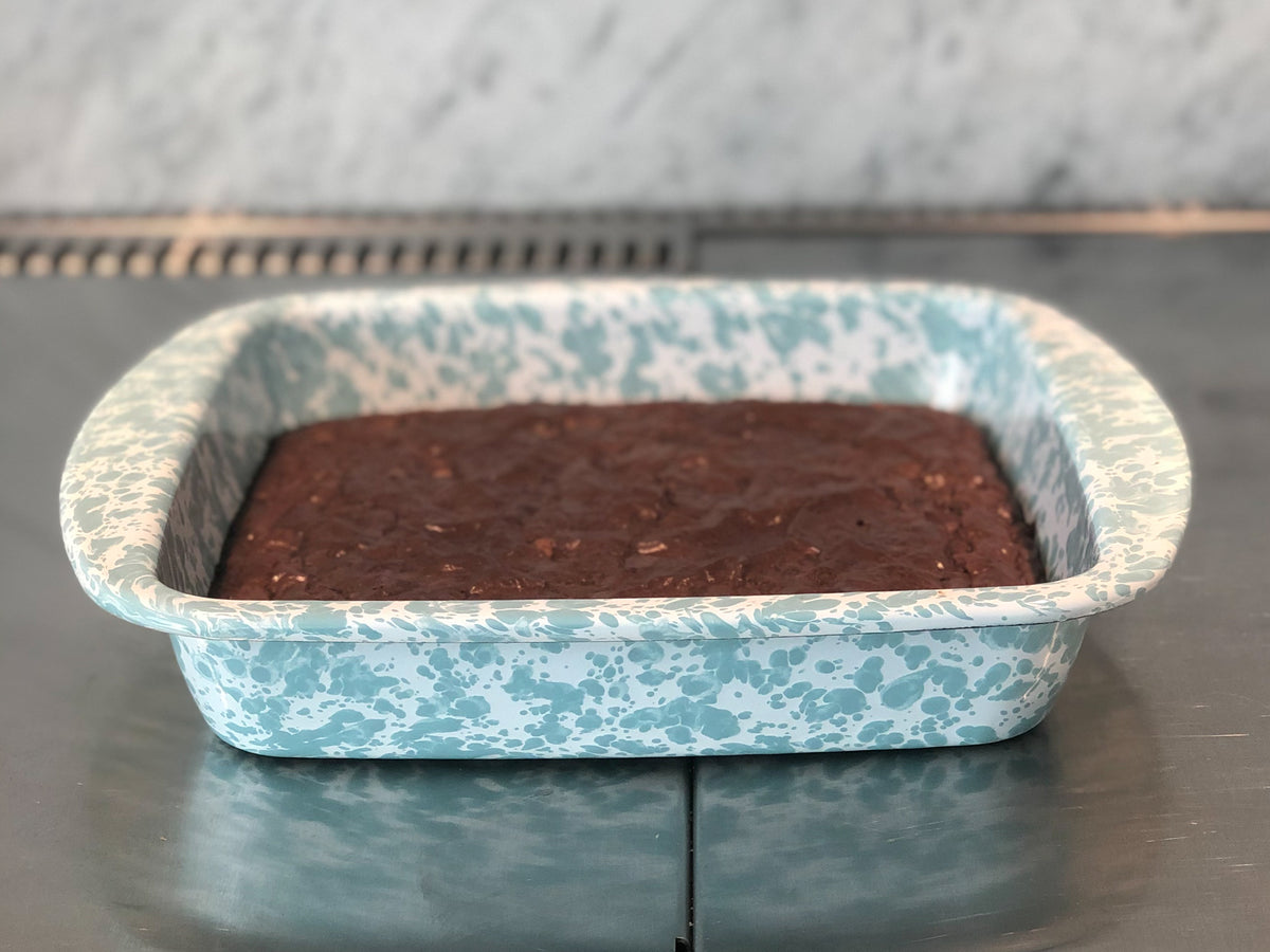 Front view of Square Trays in Sea Glass, Set of 4 showcasing blue and white splatter enamel with a brownie on a dark surface