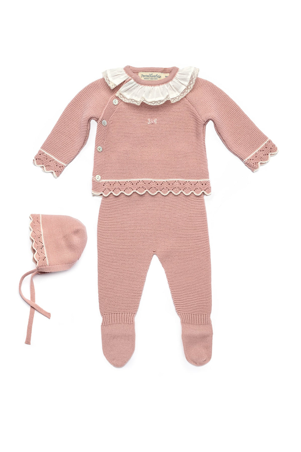 Flat lay of Bella baby set in Rose Petal: knit button-up cardigan with ruffled collar and scalloped trim, matching footed pants and bonnet on white