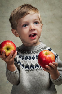 Front view of Nicolas Fair Isle Sweater in Ecru showcasing cream and navy Fair Isle knit on a child with apples