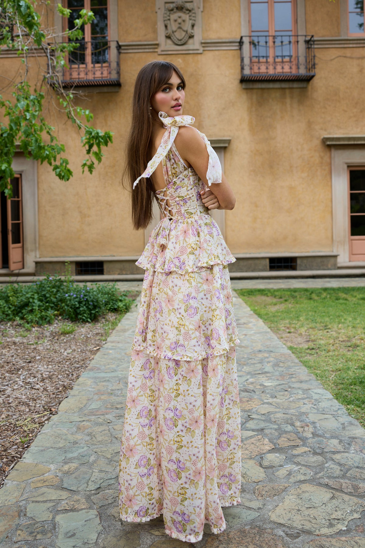 Back view of The Grace Dress in Cordoba Print showing floral organza, shoulder bow, corseted bodice and tiered skirt