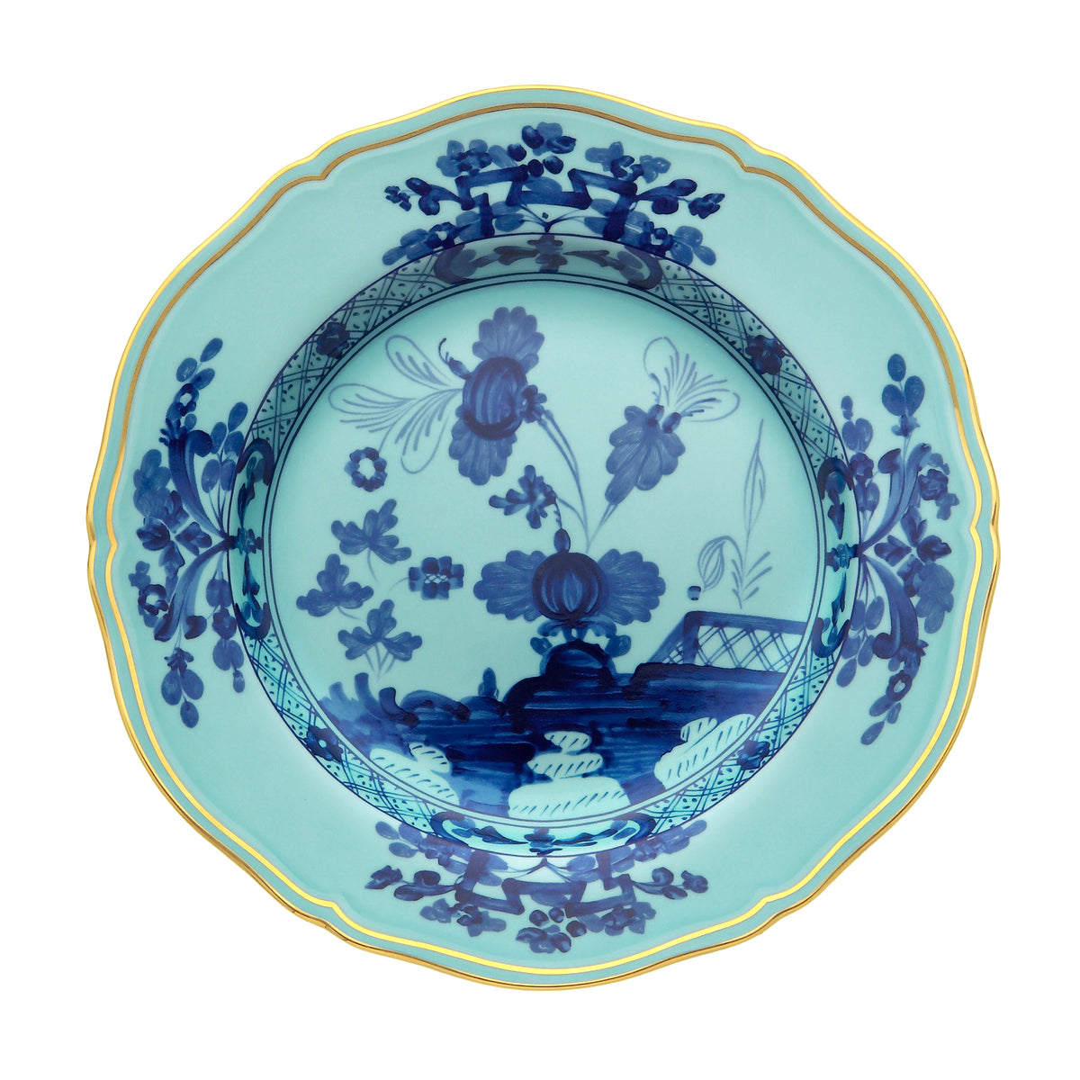 Top-down view of Oriente Italiano charger plate Iris with blue floral motif and gold scalloped rim on white background