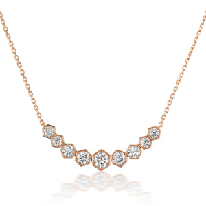 The Bezel Set Hexagon Necklace with Graduated Brilliant Diamonds features eight rose gold 18k hexagon settings, each holding a round diamond, arranged in a gentle curve on a delicate chain.
