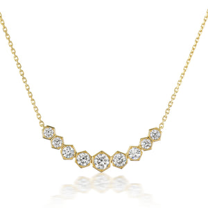 The Bezel Set Hexagon Necklace with Graduated Brilliant Diamonds features an 18k gold V-shaped pendant with nine hexagonal settings, each holding a brilliant round diamond in decreasing size from center to edges—perfect for any occasion.