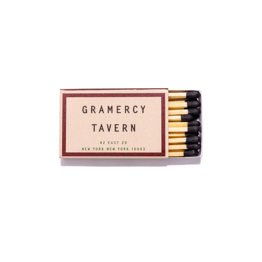 Top view of Gramercy Tavern matchbook showing open matchbox with black-tipped matches on white background