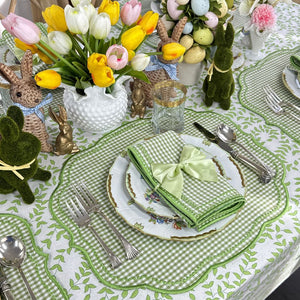Easter-themed table setting with tulips, bunnies, and green checkered tablecloth.