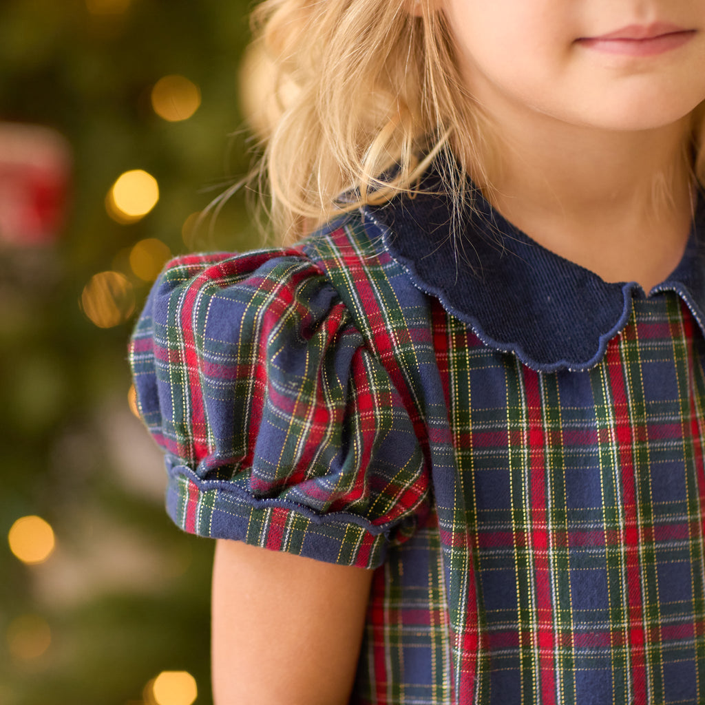Girls’ Beatrice Bubble in navy, red, and green Tinsel Tartan with subtle metallic thread, Midnight Blue Corduroy scalloped collar, and scalloped sleeve trim.