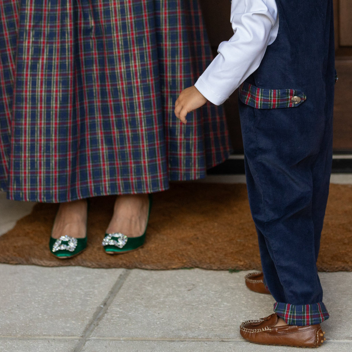 Side view of boys’ Louis Longall in midnight blue corduroy showcasing rolled tartan cuffs with a child indoors