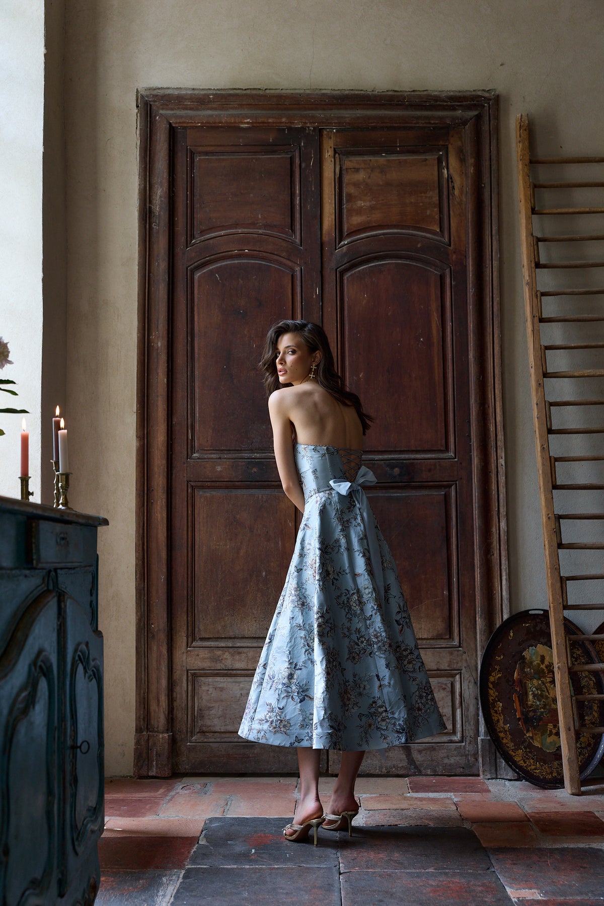 Rear view of The Hazel Dress in Light Blue Lilibet Brocade showcasing corseted back and organza bow with vintage doors
