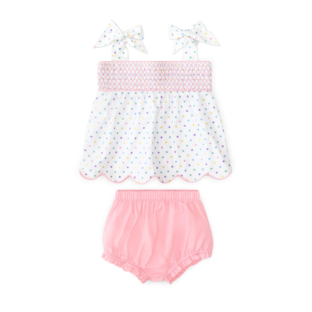 Flat lay Betsy Bloomer Set: hand-smocked Dunmore Dot top with scallop hem and tie straps, pink bloomers on white