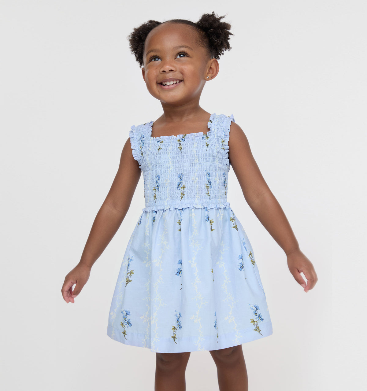 Front view of Tiny Nora Nap Dress in Bluebell Waltz on toddler model showing smocked bodice, ruffle straps and flared skirt