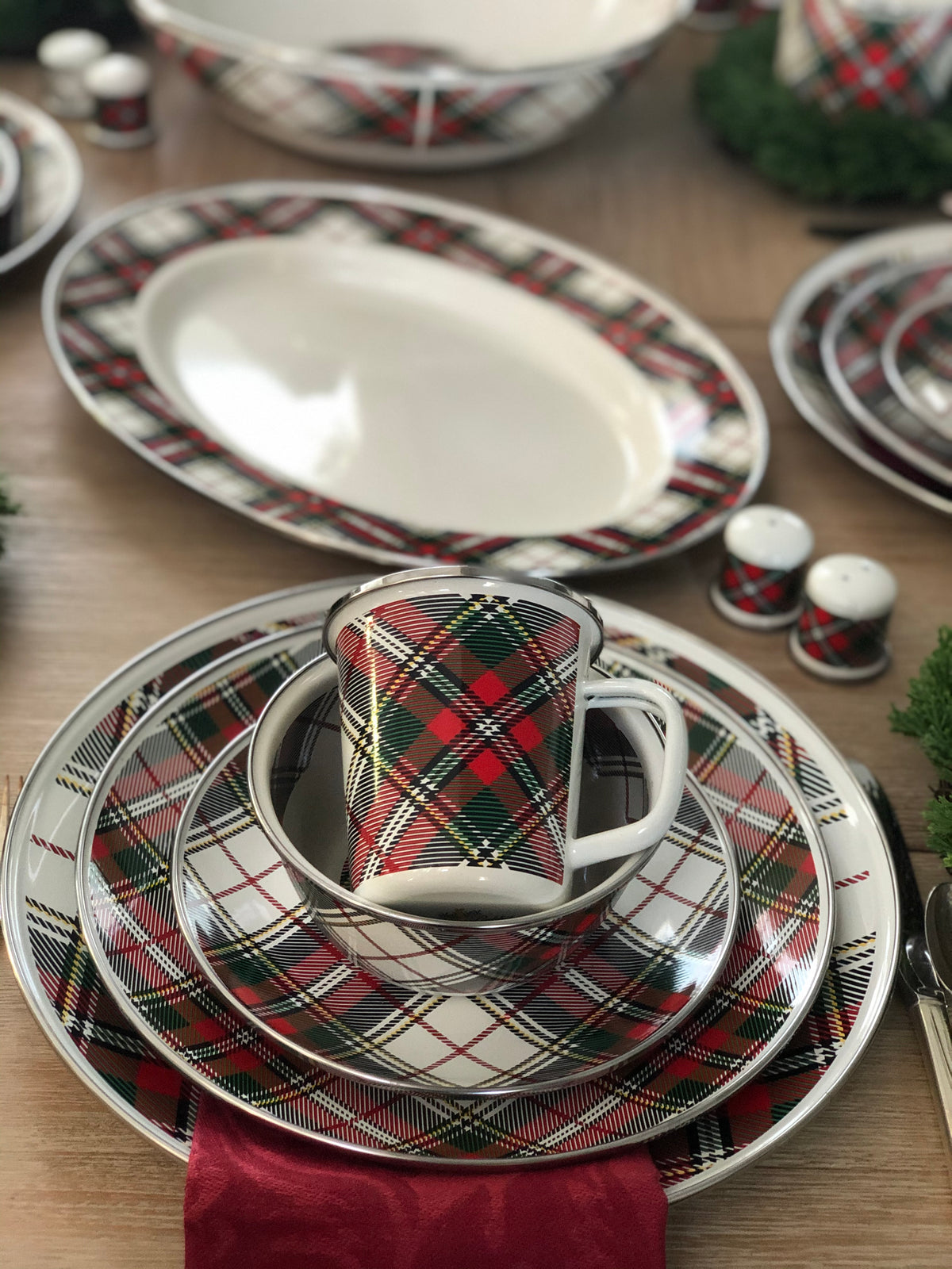 Close-up of Oval Platter in Highland Plaid showcasing its plaid porcelain enamel and stainless steel trim on a table setting