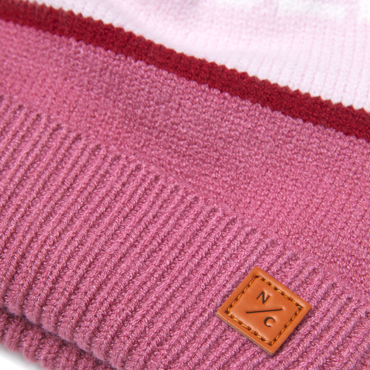 Close-up of Northern Classics Knit Pom Hat in Rose Pink and Ballerina Pink showcasing its knit texture on a light background