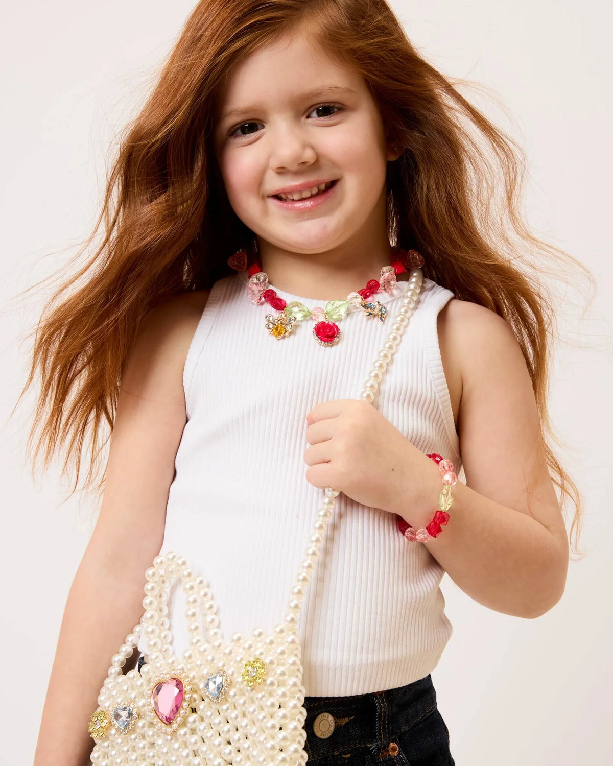 Front view of Make It Rosey Mini Bead Kit showcasing colorful jewelry worn by a child on a light background