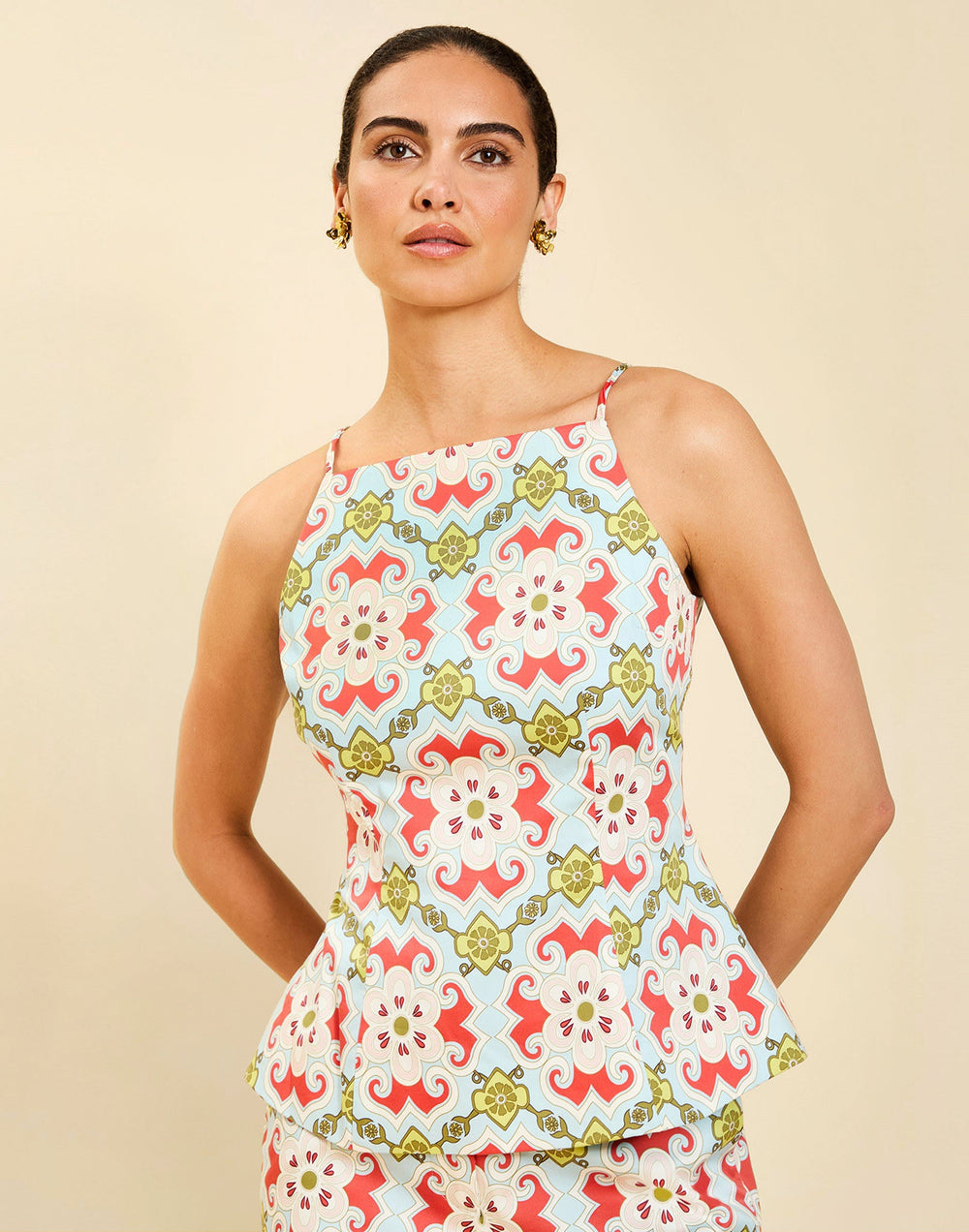 Woman wearing the Mestiza Havana Top in Quatrefoil Sierra print, featuring a bib-neck silhouette, fitted waist, princess seaming, and thin shoulder straps in crisp cotton poplin.