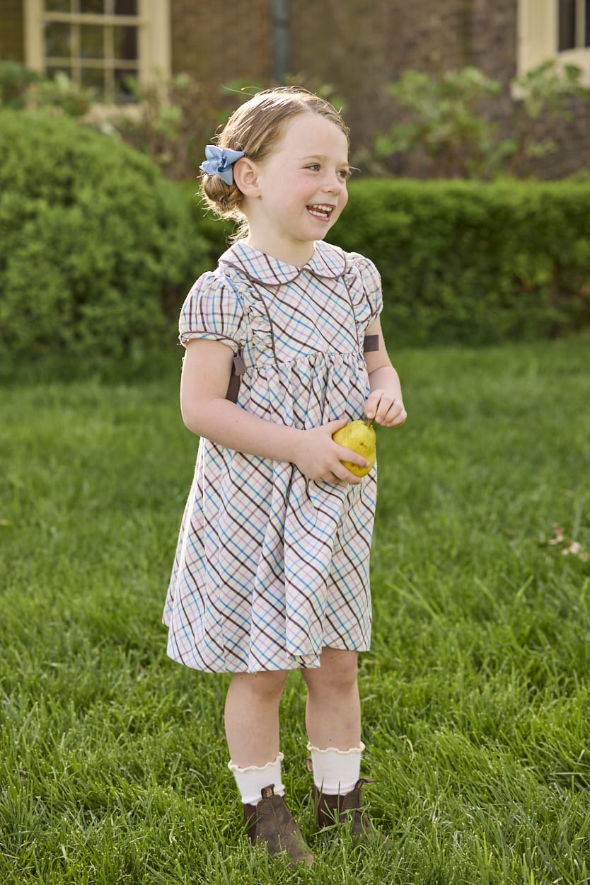 Little English traditional children's clothing. Short sleeve peter pan dress in blue, pink, and brown Wilmington Plaid with brown corduroy piping and bow details for little girls.