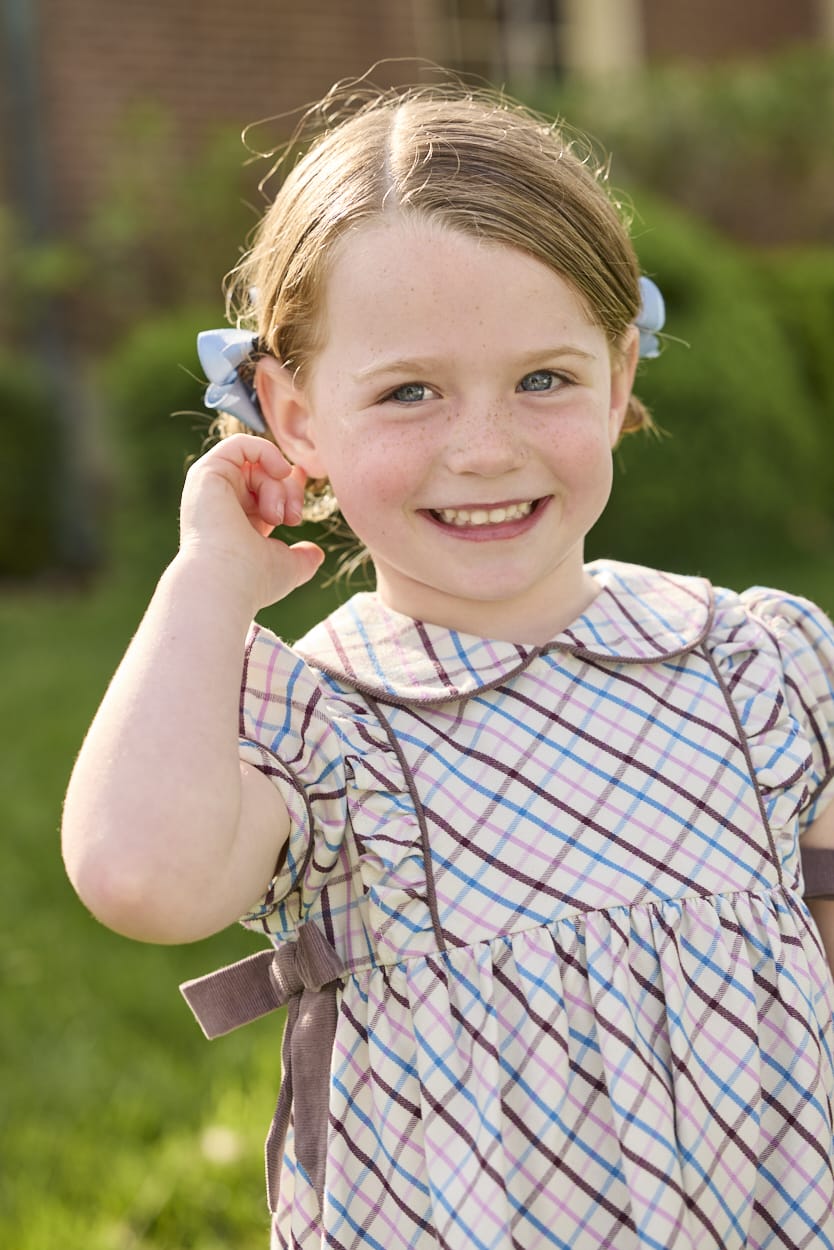 Little English traditional children's clothing. Short sleeve peter pan dress in blue, pink, and brown Wilmington Plaid with brown corduroy piping and bow details for little girls.