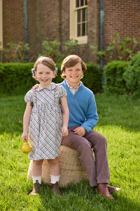 Little English traditional children's clothing. Boys stormy blue quarter zip sweater layered over blue, pink, and brown Wilmington Plaid button down shirt and paired with chocolate brown corduroy classic pants.  Short sleeve peter pan dress in blue, pink, and brown Wilmington Plaid with brown corduroy details for little girls.