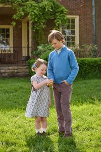 Little English traditional children's clothing. Boys stormy blue quarter zip sweater layered over blue, pink, and brown Wilmington Plaid button down shirt and paired with chocolate brown corduroy classic pants.  Short sleeve peter pan dress in blue, pink, and brown Wilmington Plaid with brown corduroy details for little girls.