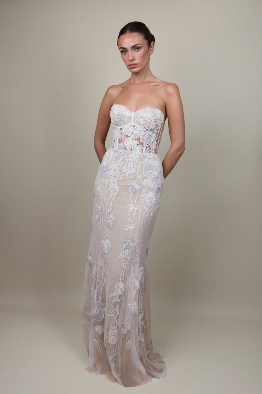 Front view of Monstera Eclipse Bustier Gown with strapless cupped bodice and sheer embroidered leaf applique over nude skirt
