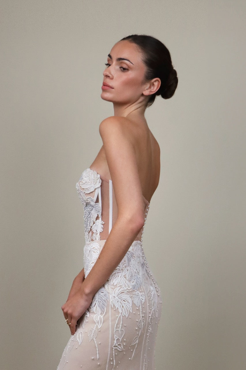 Side view of Monstera Eclipse Bustier Gown with strapless corset, sheer side panels, embroidered leaf applique and beading