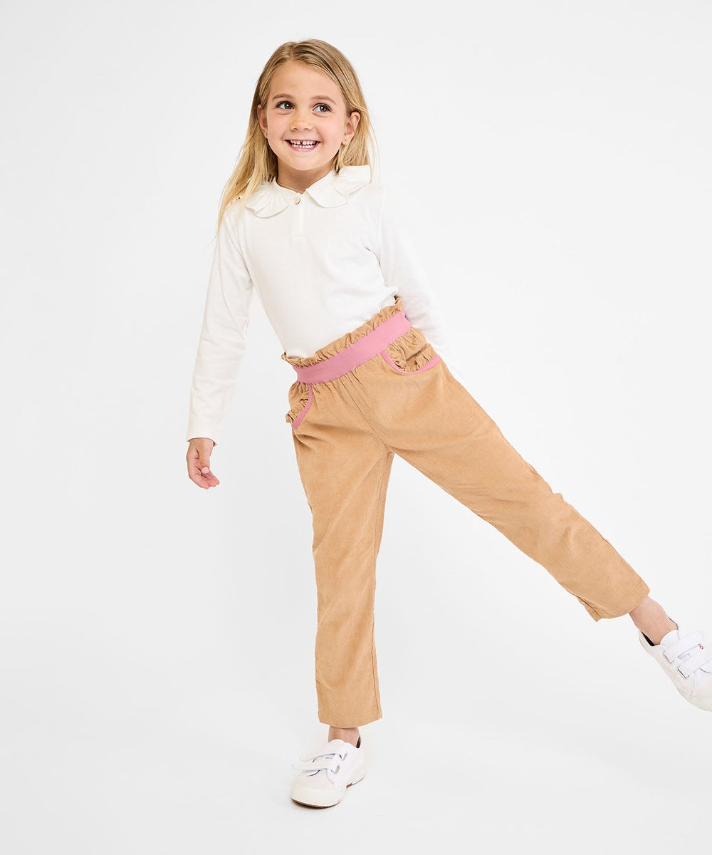 Front view of Hen T-Shirt in vanilla piping on child model showcasing ruffle collar, single-button front, and long sleeves on white background