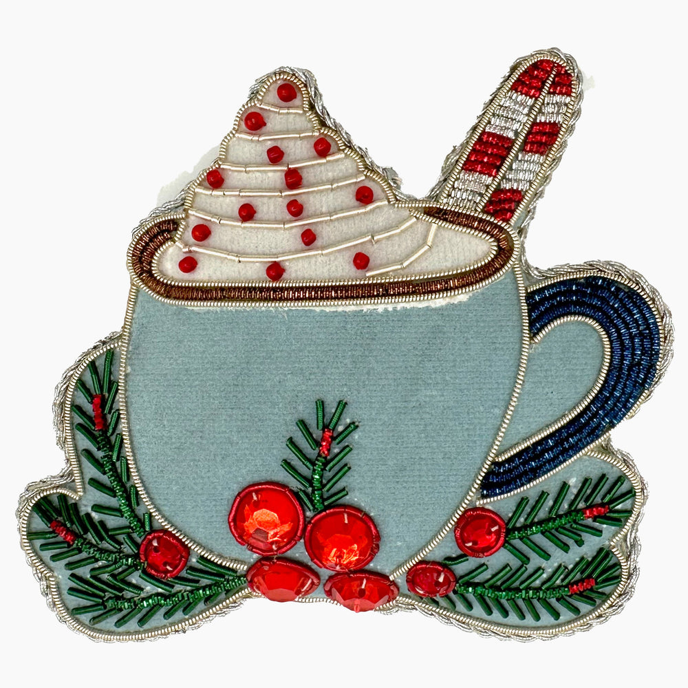 Front view of Holiday Hot Chocolate ornament showing beadwork whipped-cream top, candy-cane stirrer, and red sequin holly