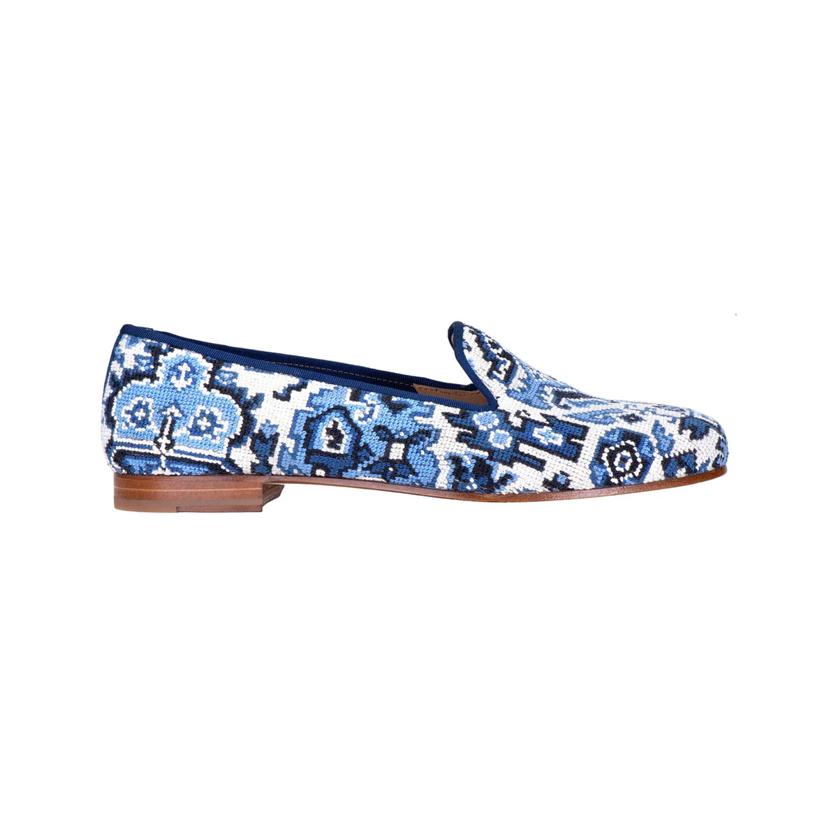 Side view of Heriz slipper in Lapis showcasing a blue and white patterned upper with a low brown sole on white background
