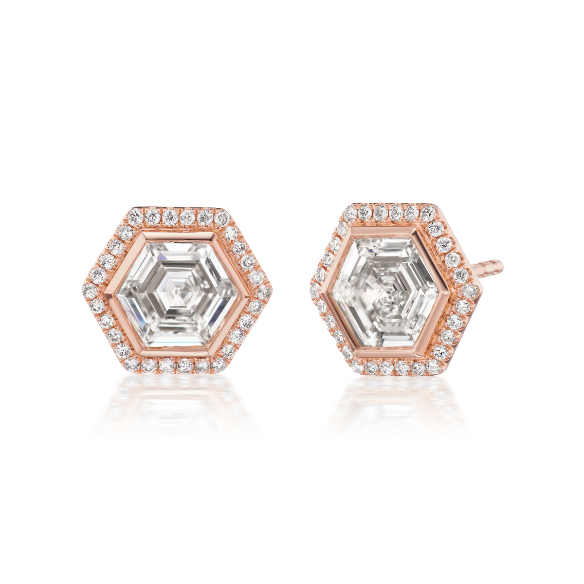 Bezel Set Hexagon Diamond Studs in Rose Gold with Pavé feature a central hexagon diamond surrounded by pavé-set round diamonds in 18k rose gold, offering a modern and elegant look that beautifully reflects light.