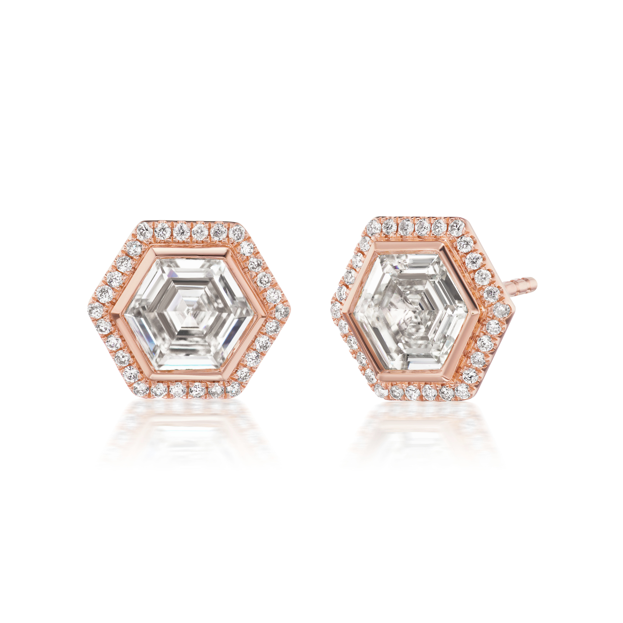 Bezel Set Hexagon Diamond Studs in Rose Gold with Pavé feature a central hexagon diamond surrounded by pavé-set round diamonds in 18k rose gold, offering a modern and elegant look that beautifully reflects light.