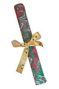 Hand marbled holiday festive gift wrapping paper roll tied with yellow inner child ribbon