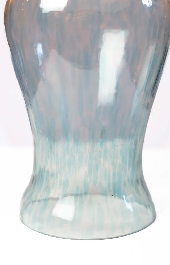 Close-up of clear aqua glass hurricane vase showing marbled blue and clear finish on flared base against white background