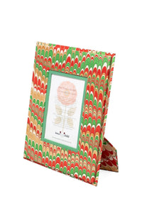 Angled view of Hand-Marbled Large Wall 5x7 Picture Frame in Holiday Jingle with red, green, and tan marbled paper
