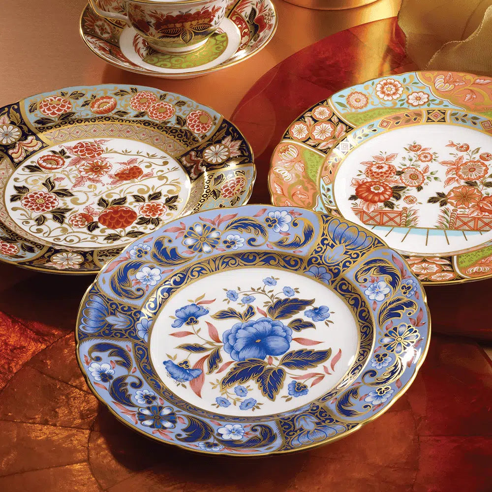 Close up of Imari Accent Collection plates showing floral Imari patterns and 22 carat gold trim on red fabric background