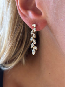 Close-up of a woman's ear wearing Marquise Diamond Waterfall Drop Earrings, featuring a gold leaf-inspired design with marquise and brilliant cut diamonds arranged in a cascading pattern.