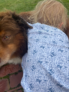 Side view of Farm Kids Henley Pajamas showcasing a blue and white farm print beside a brown dog outdoors