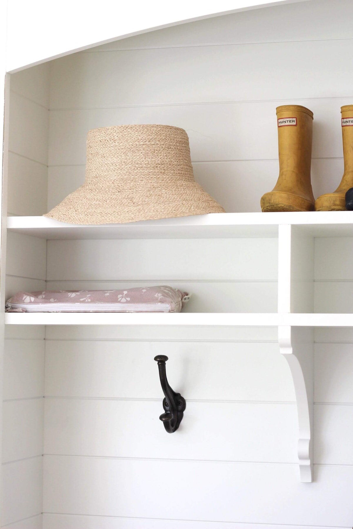 Front view of Raffia bucket hat showcasing braided natural raffia and flared brim on a white shelf